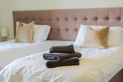 a pile of towels sitting on top of a bed at Hillside House in Dunfermline