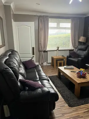 a living room with a leather couch and a coffee table at Rowan in Bellshill