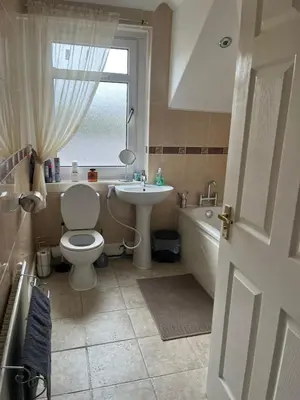 a bathroom with a toilet and a sink and a tub at Rowan in Bellshill