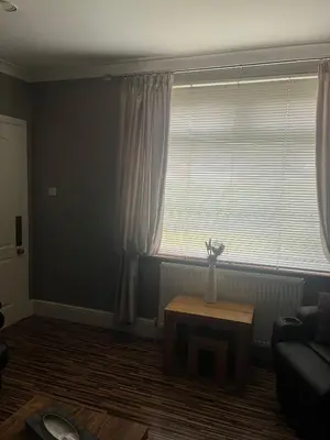 a living room with a vase of flowers on a table at Rowan in Bellshill