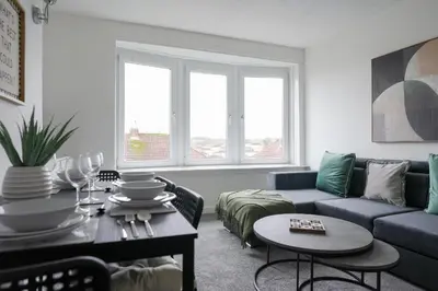 a living room with a blue couch and a table at 2 BDR Apartment By Caledonia Luxe Stays Short Lets & Serviced Accommodation Airdrie in Airdrie