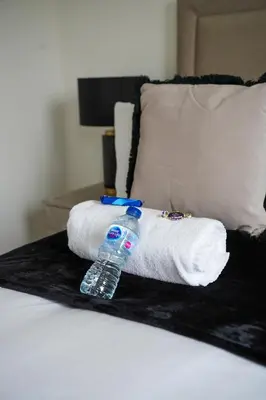 a bottle of water sitting on top of a bed at 2 BDR Apartment By Caledonia Luxe Stays Short Lets & Serviced Accommodation Airdrie in Airdrie