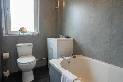 a bathroom with a toilet and a bath tub at 2 BDR Apartment By Caledonia Luxe Stays Short Lets & Serviced Accommodation Airdrie in Airdrie