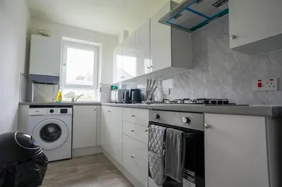 a kitchen with a washing machine and a washer at 2 BDR Apartment By Caledonia Luxe Stays Short Lets & Serviced Accommodation Airdrie in Airdrie