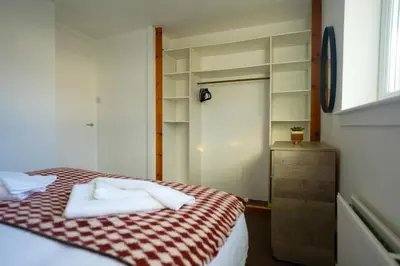 a bedroom with a bed with a red and white checkered blanket at Train House in Dunfermline
