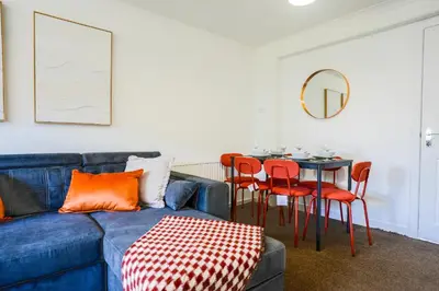 a living room with a blue couch and a table at Train House in Dunfermline