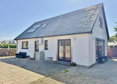 a white house with a black roof at Sealladh Mor-Cottage in Lamlash, Arran in Lamlash