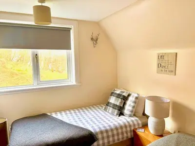 a small bedroom with a bed and a window at Four Woodside in Craighouse