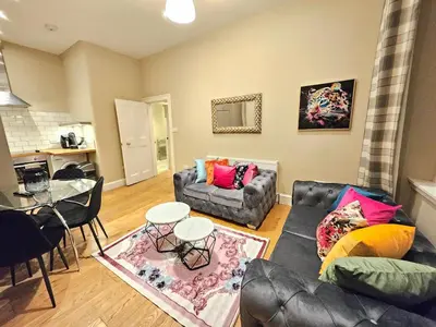 a living room with a couch and a table at 2 Bedroom Apt, 4 Beds, 3 TV near Fountain Park in Edinburgh