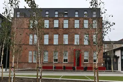 a red brick building with windows and trees in front at For Students Only - Willowbank in Glasgow in Glasgow