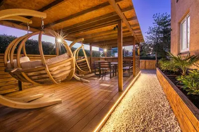 a deck with a swing and a table and chairs at Private Hot Tub - Zen & Bubbles in Edinburgh