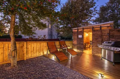 a backyard with a wooden deck with a grill and a house at Private Hot Tub - Zen & Bubbles in Edinburgh