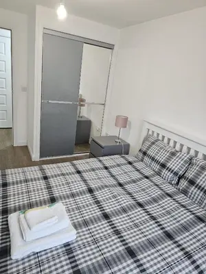 a bedroom with a bed with a book on it at Stylish 2-Bed Flat with Open-Plan Living plus Parking in Edinburgh
