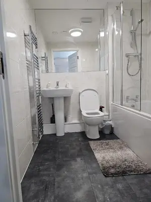 a bathroom with a toilet and a sink and a shower at Stylish 2-Bed Flat with Open-Plan Living plus Parking in Edinburgh
