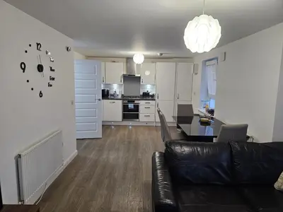 a living room and kitchen with a couch and a table at Stylish 2-Bed Flat with Open-Plan Living plus Parking in Edinburgh