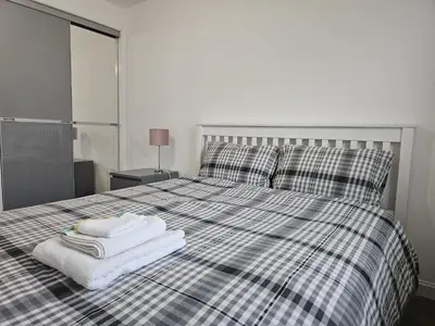 a bedroom with a bed with towels on it at Stylish 2-Bed Flat with Open-Plan Living plus Parking in Edinburgh