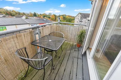 a patio with a table and chairs on a balcony at Free Parking - Central - 2 Bedroom - 4 Guests in Livingston