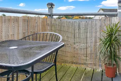 a table and chairs on a balcony with a fence at Free Parking - Central - 2 Bedroom - 4 Guests in Livingston