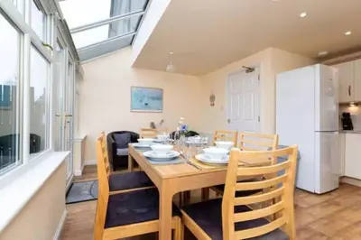 a dining room with a wooden table and chairs at 4 Bedroom Townhouse In Stirling in Stirling