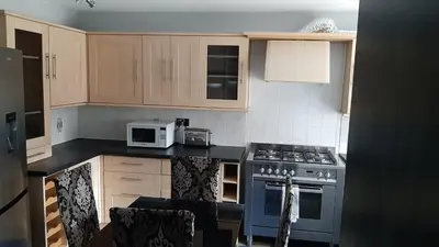 a kitchen with a stove and a microwave at 3 Bedroom Cozy House-Short and Long Stay in Moffat
