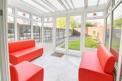 a room with two red chairs and windows at 3 Bedroom Cozy House-Short and Long Stay in Moffat