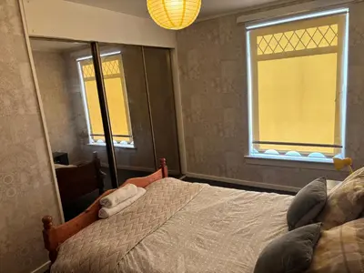 a bedroom with a bed and a large mirror at OakHouse- Entire 3 Bedroom Terrace House with Free Parking in Cumbernauld