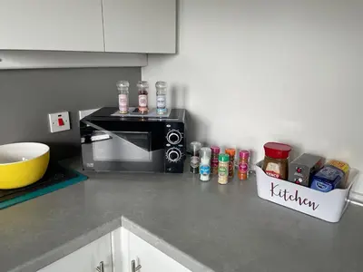 a kitchen with a counter top with a microwave at Spacious two bedroom flat, entire property in Greenock