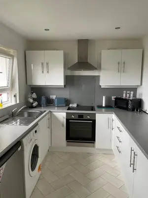 a kitchen with white cabinets and a dishwasher at Spacious two bedroom flat, entire property in Greenock