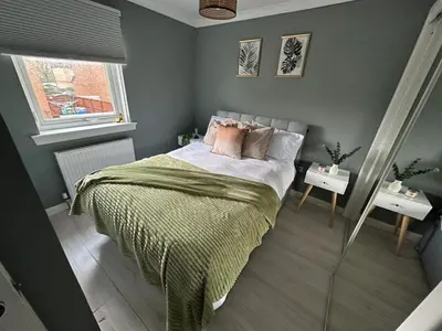 a bedroom with a bed and two night stands at Cosy Glasgow Barrowlands stay-spacious & free parking in Glasgow