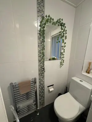 a bathroom with a white toilet and a mirror at Cosy Glasgow Barrowlands stay-spacious & free parking in Glasgow