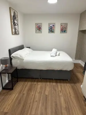 a bedroom with a large bed and a wooden floor at Edinburgh Rose Suites 1BHK Central EB4 in Edinburgh