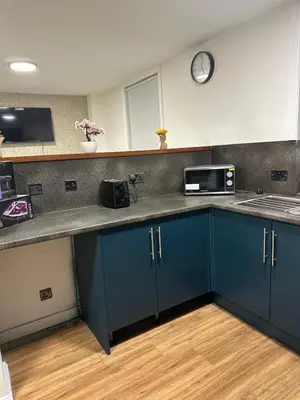 a kitchen with blue cabinets and a clock on the wall at Edinburgh Rose Suites 1BHK Central EB4 in Edinburgh