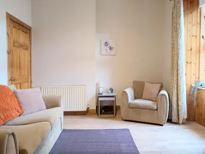 a living room with a couch and a chair at Kintyre apartment in Campbeltown