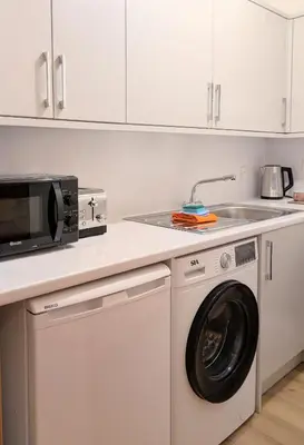a kitchen with a washing machine and a sink at Kintyre apartment in Campbeltown