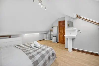a white bedroom with a bed and a sink at Spacious 5BR Home in Cardiff Bay with Office Area in Moffat