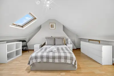 a white bedroom with a bed and a skylight at Spacious 5BR Home in Cardiff Bay with Office Area in Moffat