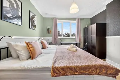 a bedroom with a large bed and a desk at Spacious 5BR Home in Cardiff Bay with Office Area in Moffat