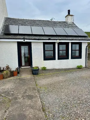 a white house with solar panels on the roof at Seaview Cottage Bellochantuy