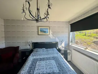 a bedroom with a bed and a chandelier at Seaview Cottage Bellochantuy