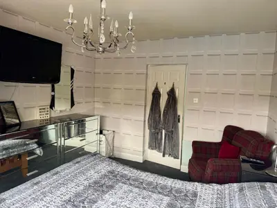a living room with a couch and a tv and a chandelier at Seaview Cottage Bellochantuy