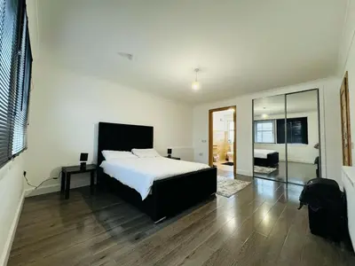 a bedroom with a white bed and a wooden floor at 3 bedroom luxury Apartment in Prestwick