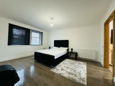 a bedroom with a bed and a rug at 3 bedroom luxury Apartment in Prestwick