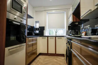 a kitchen with stainless steel appliances and a window at Caldwell House in Glasgow