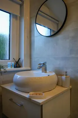 a bathroom with a white sink and a mirror at Caldwell House in Glasgow