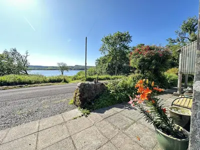 a sidewalk with flowers on the side of a road at Dunmore Cottage in Tarbert