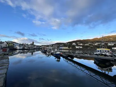 a river with boats docked next to a bridge at Dunmore Cottage in Tarbert