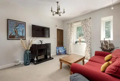 a living room with a red couch and a fireplace at Andy's Pad in Edinburgh