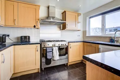 a kitchen with wooden cabinets and a stove top oven at Southend perfect Stays in Moffat