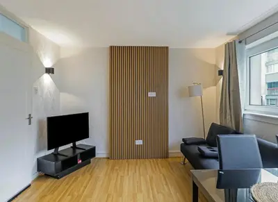 a living room with a couch and a television at Free Parking - 3 Bedrooms - Sleeps 7 - Airport in Paisley