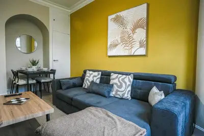 a living room with a blue couch and a table at Neilston Gateaway in Paisley